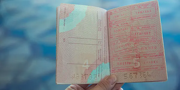 Ένα χέρι που κρατάει ένα ανοιχτό διαβατήριο.
